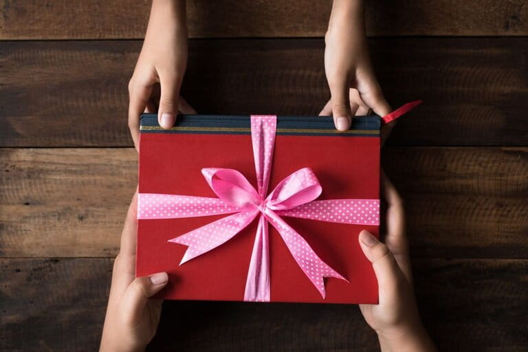 the image of a student's hand giving a gift of a book to the teacher the image of a student's hand giving a gift of a book to the teacher