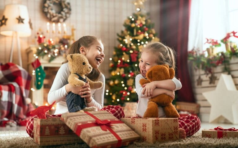 Two little girls are excitedly opening meaningful gifts for Christmas Two little girls are excitedly opening meaningful gifts for Christmas