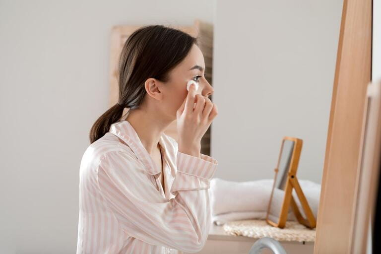 Beautiful young woman with cotton wool in bathroom Beautiful young woman with cotton wool in bathroom